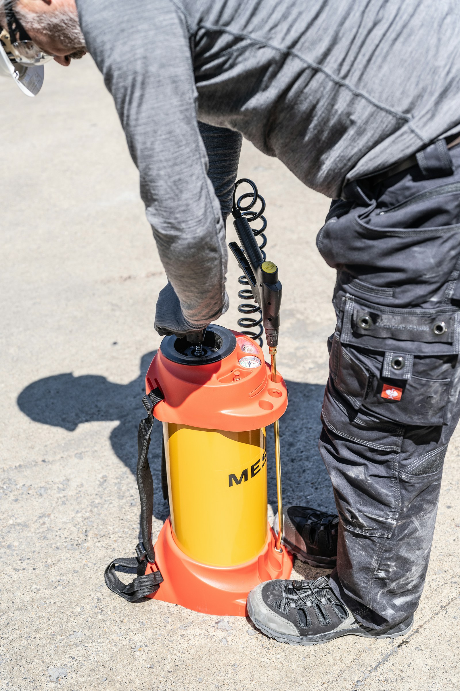 A technician operating a pressure sprayer for pest treatment
